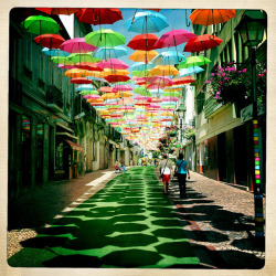 orientaltiger:  In Águeda, a small Portuguese town, some streets are decorated with colorful umbrellas. The umbrellas cover heads from the hot summer sun. 