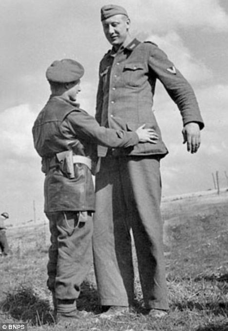 Jakob Nacken tallest man in the German Army (7’ 6"), surrenders to British Cpl. Bob Rober