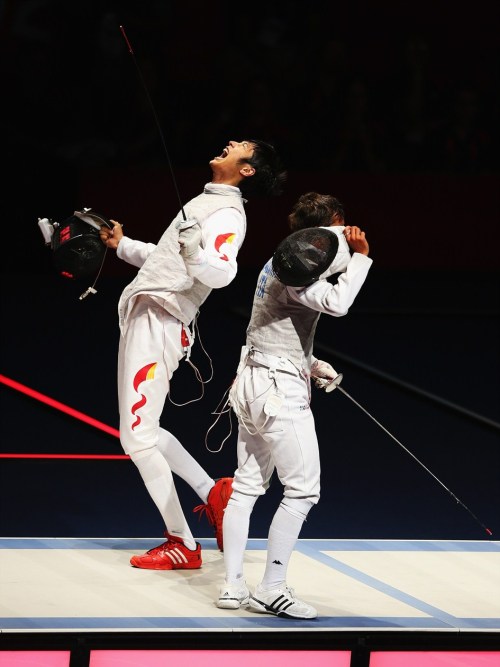 modernfencing: [ID: a foil fencer with his mask off, screaming to celebrate a win as his opponent wa