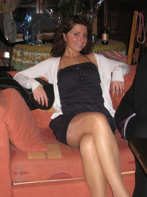 Candid pic of a pretty brunette in black dress and shiny tan pantyhose crossing her legs https://all