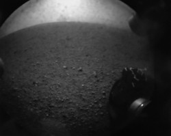 In this image from NASA TV, shot off a video screen, one of the first images from the Curiosity rover is pictured of its wheel after it successfully landed on Mars.