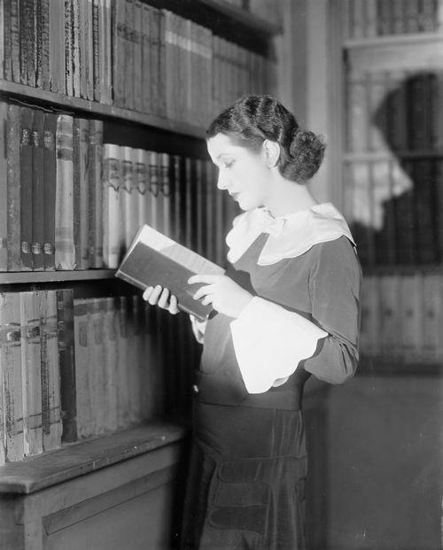 Lynn Fontanne reading in library, 1928. Fontanne (1887-1983) was a British actress and major stage s
