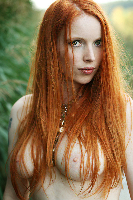 Luscious ginger redhead, showing her breasts and straight hair.