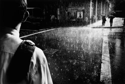 elisebrown:Sydney. Summer rain . A man stands huddled under awnings on the corner of George & Ma