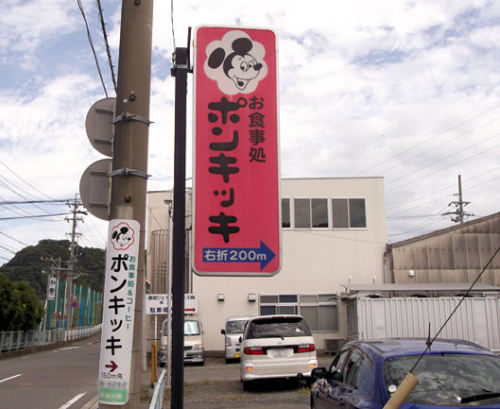caravanserai:  どの辺りから突っ込めばいいのやら…… なかなか精神的破壊力の大きな看板です。 とりあえず、手前のピンクの立て看板と 電柱広告に表記されている距