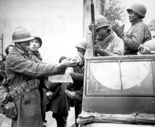 greatestgeneration:French soldiers share candy with American soldiers in Rouffach, France. February 
