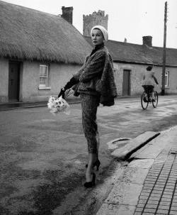 hoodoothatvoodoo:  Barbara Goalen in a shaggy woollen suit with sleeveless sling cape by Sybil Connolly, photo by Milton Greene in the village of Trim, Ireland, 1953 