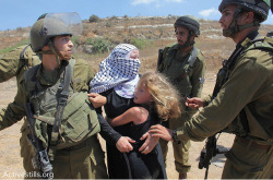  Israel soldiers arresting Nariman Tamimi, while her children try to de-arrest her, at the entrance to Nabi Saleh’s water spring on August 24, 2012, during the violent dispersal of the weekly protest against the occupation held in the village. Photo