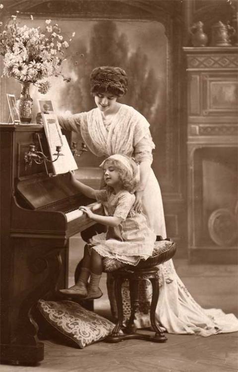 Teaching to play the piano and read music. Vintage photograph. &ldquo;Musical training is a more