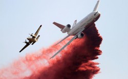 politics-war: A firefighting tanker plane drops fire retardant on homes threatened by the Taylor Creek Fire outside Cle Elum, Washington State, US 