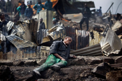 Joseph Mwangi, 34, Sits In A State Of Shock After Discovering The Charred Remains