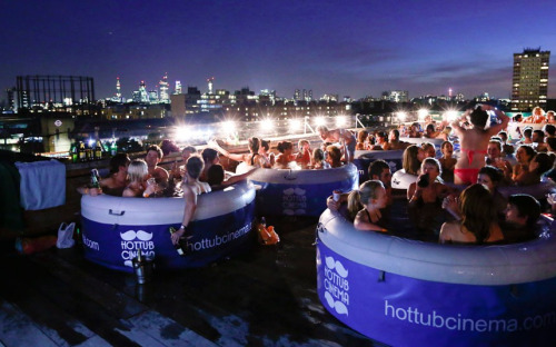 People sit in hot tubs at a Hot Tub Cinema event on a warehouse roof in Hackney, east London Picture