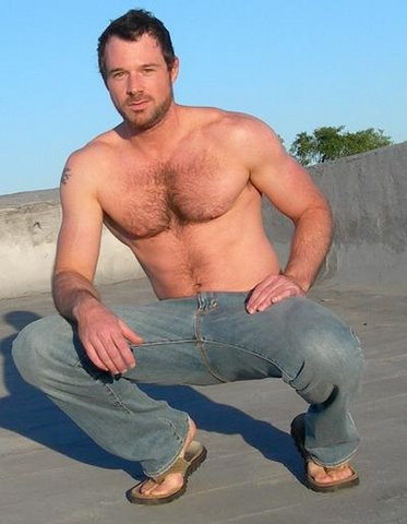 Rugged shirtless hairy guy in jeans and flip flops.  