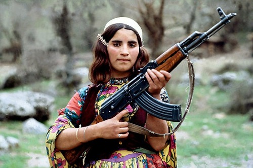A Kurdish girl dons an AKM/AK47 to protect her family against Ba'ath party thugs. 1980’s.