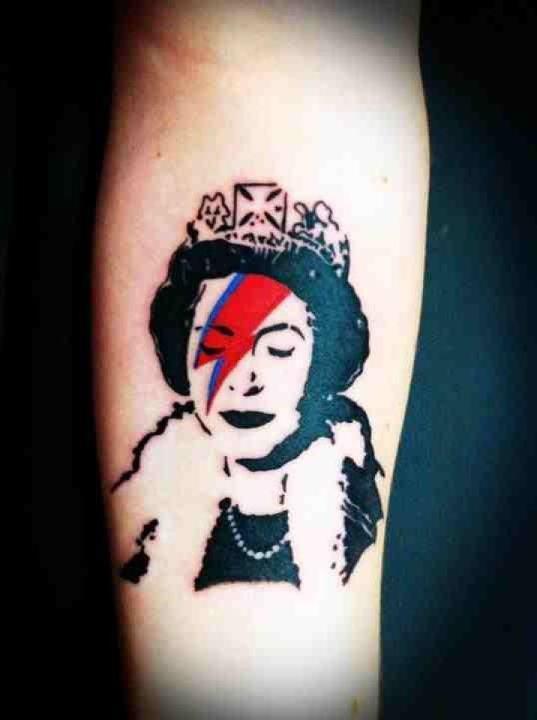 This is my latest addition to my skin. Its a piece originally done by the street artist Banksy. Its obviously, the Queen with the David Bowie Ziggy Stardust lightening bolt.
There is no major story behind it to be honest. But, it was the first tattoo...