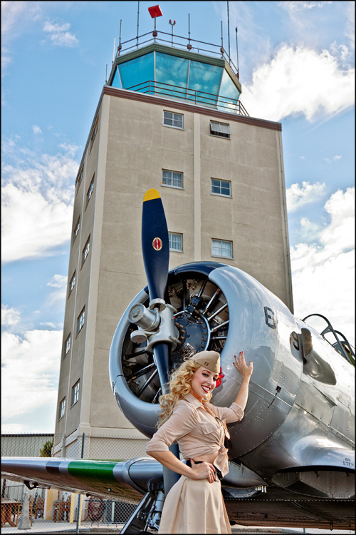 Beautiful blonde aircraft girl caressing plane