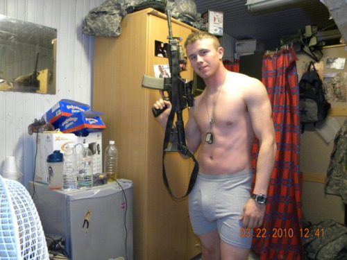 Sexy marine in boxer briefs holding a gun in the barracks.