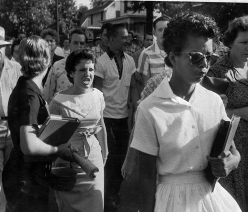 patron-saints: Fifteen-year-old Elizabeth Eckford endures with dignity the jeers of a white mob duri