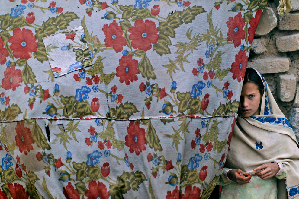 An Afghan refugee girl stands in the doorway of her home in a slum area on the outskirts of Islamabad, May 7, 2012. (Muhammed Muheisen/Associated Press)#