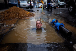 troposphera:   Caracas, Venezuela: A worker is partially submerged as he tries to repair a broken pipe.    Photograph: Rodrigo Abd/AP  