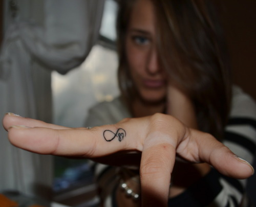 Tiny infinity symbol tattoo on the right ring finger