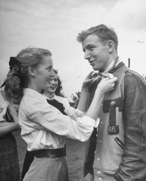  Teen Fads, 1947    Girl ties her hair scarf around her boyfriends neck as a fond