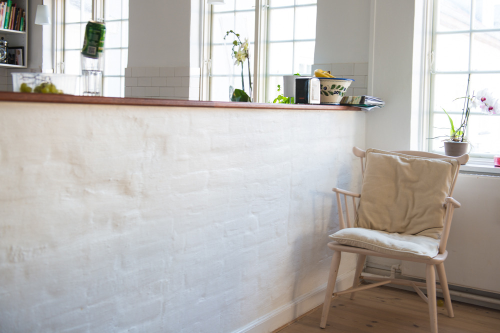 A white washed brick kitchen half wall adds texture where any defects in the wall simply add interesting character as a backdrop to the dining area. Perfection is overrated!