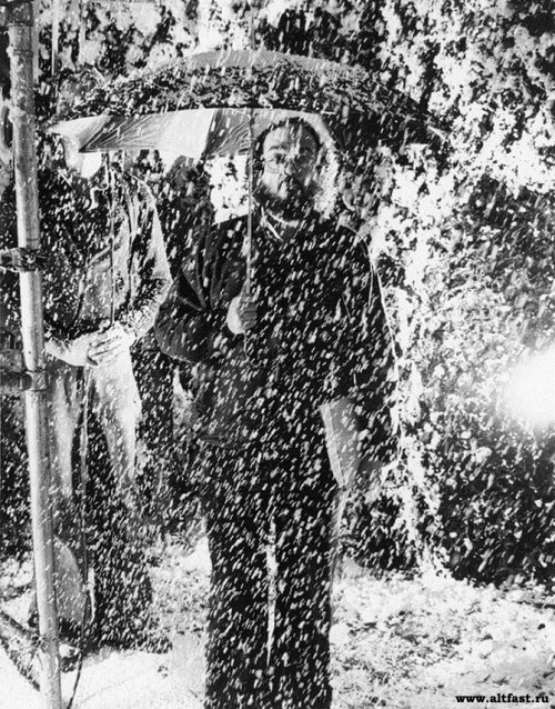 Behind-the-scenes photograph of director Stanley Kubrick standing on the set of the hedge maze durin