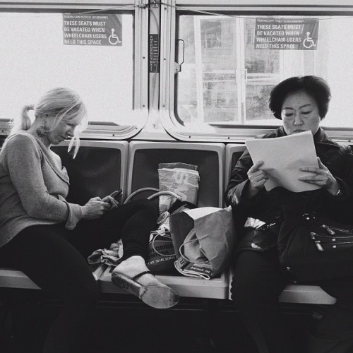 The woman on the right keeps squirming away from the belongings of the woman on the left who is tota