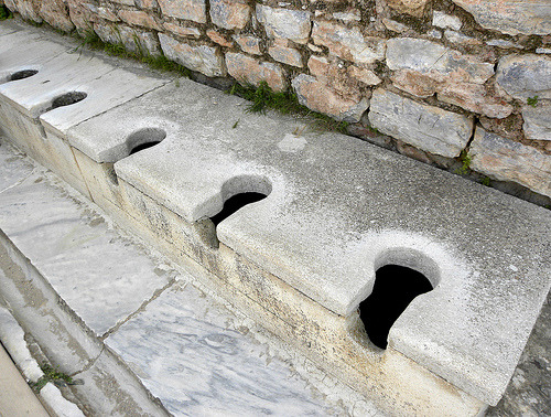 Ancient Roman Public Toilets,A simple row of toilets.  Waste was carried away by constantly flowing 