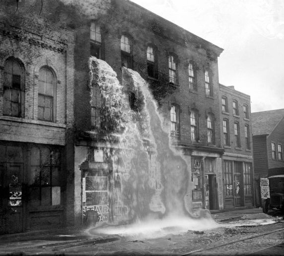abbyjean:  Streams of confiscated liquor pour out of upper windows of three-story
