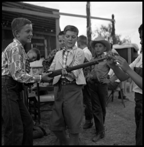 gunsandposes:Boys examining a rifle. Shackelford County, Texas. Date unknown, photo by Sally Brittin