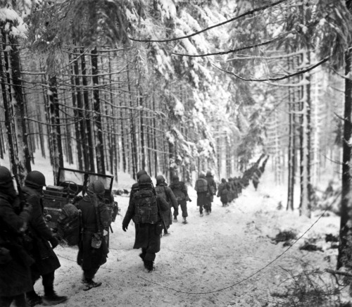 operationbarbarossa:Troops of the US 289th Infantry Regiment march in the snowy woods to cut off the