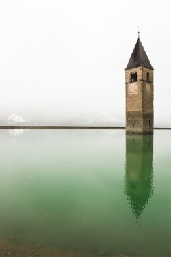 abandonedporn:   While under the fascist rule, this small Italian town was flooded for the “greater good” of the nation: the water was meant to fuel a hydroelectric plant, but it was never built. The only remnant of the town is this church tower,