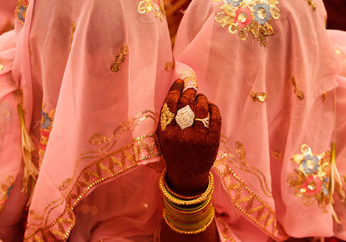 Muslim brides interact with each other as they wait for their wedding ceremonies to start during a m