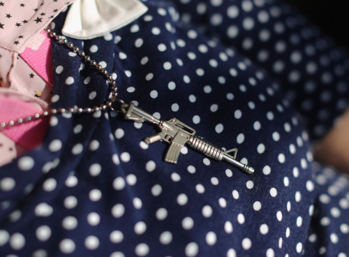 An Israeli woman wears a trinket in the shape of an M16 rifle as she sits in a cafe on November 20, 