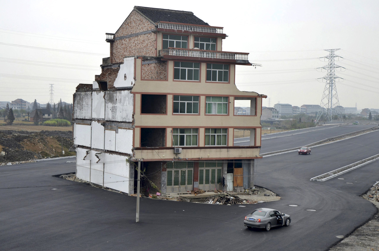 Casa no meio de uma rodovia na China
Um casal de idosos se recusaram a assinar o contrato de demolição, alegando que o valor era muito baixo para eles construirem uma nova casa.
Deste modo, a casa deles ficou no meio da rodovia.