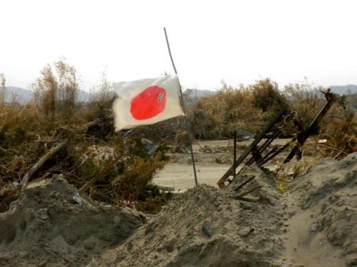 Japanese flag among piles of rubble following the Tōhoku earthquake and tsunami, April 2011