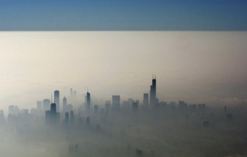 Blue sky is seen over a blanket of fog enveloping the skyline of Chicago, as photographed from an ai