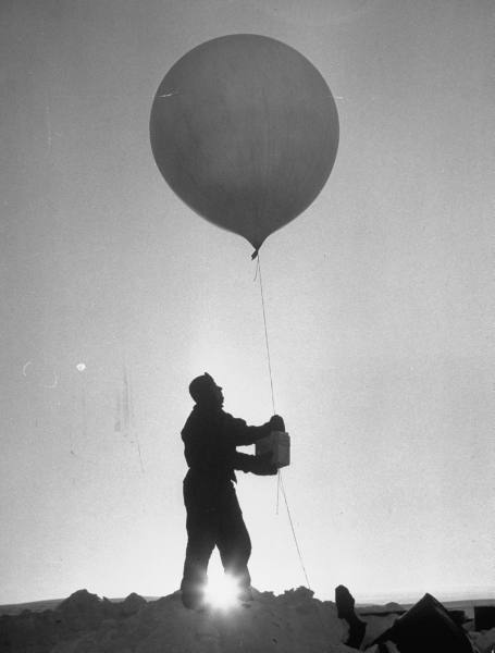 adanvc:  A man conducting a scientific weather experiment with a balloon, Antarctica,