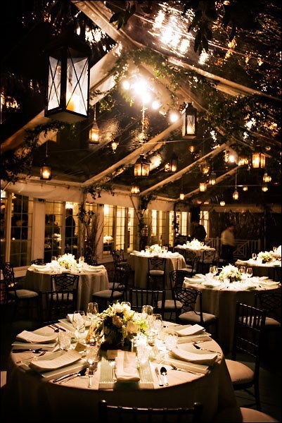 A Tent Wedding Decorated With Hanging Candle Lanterns