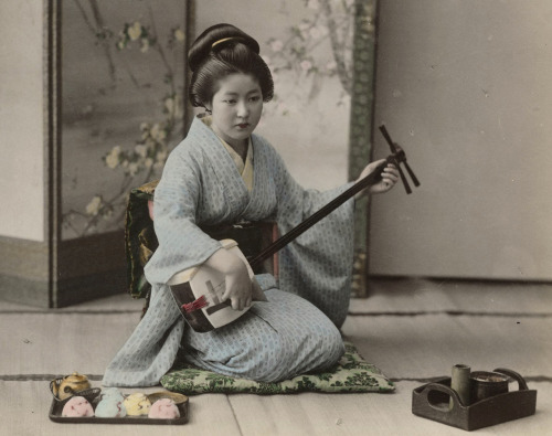 Hand-colored photo of woman playing shamisen. 1880’s or 1890’s, Japan. Photographer Koza