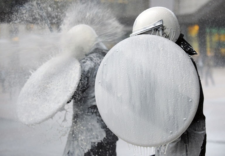 Moo juice (police in Brussels are sprayed with milk by dairy farmers protesting the