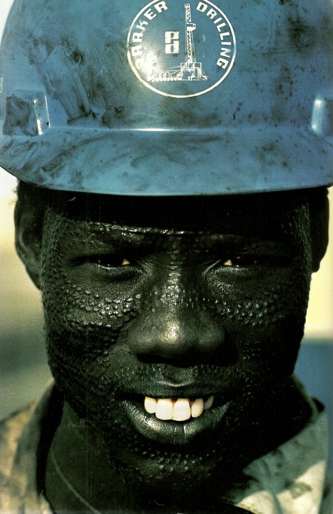 vintagenatgeographic: Nuer tribesman wears a hard hat for his job on an oil rig in Sudan National Ge