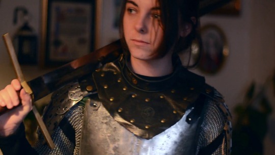 and-speak:they/them pov you’re the royalty i’ve sworn to protect. [video description: op is filmed from the chest up wearing metal armor. they bring their sword up and rest it on one shoulder which makes a clinking sound. they then look up and smile